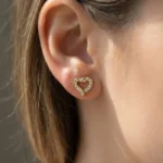 brincos dourados mulher em forma de coração com brilhantes